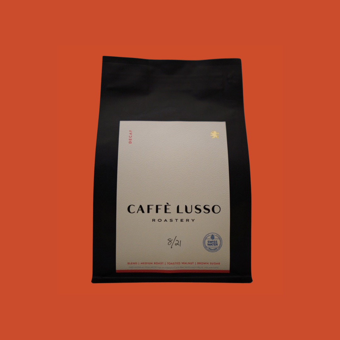 Caffè Lusso coffee bag of Swiss Water Decaf on an orange background