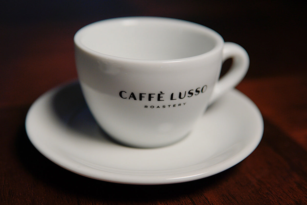 White porceline cappuccino cup with hite saucer, Caffe Lusso Logo on front
