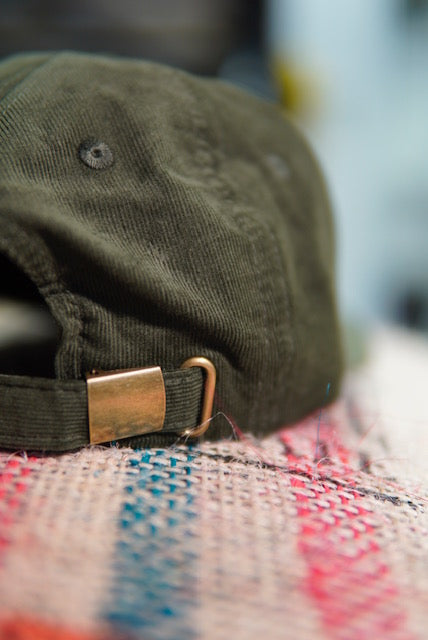 Back of an alive green hat, showing the brass closer.